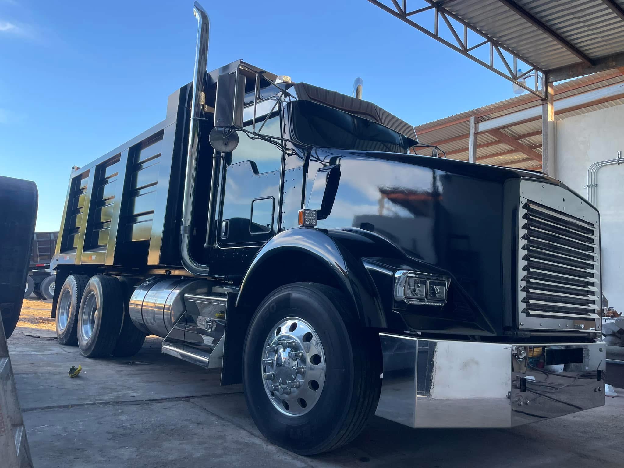 White dump truck with raised dump body in MR Machinery shop